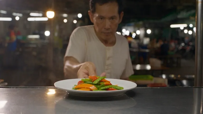 Original video frame at thirteen seconds: the chef presents a plate of cooked vegetables